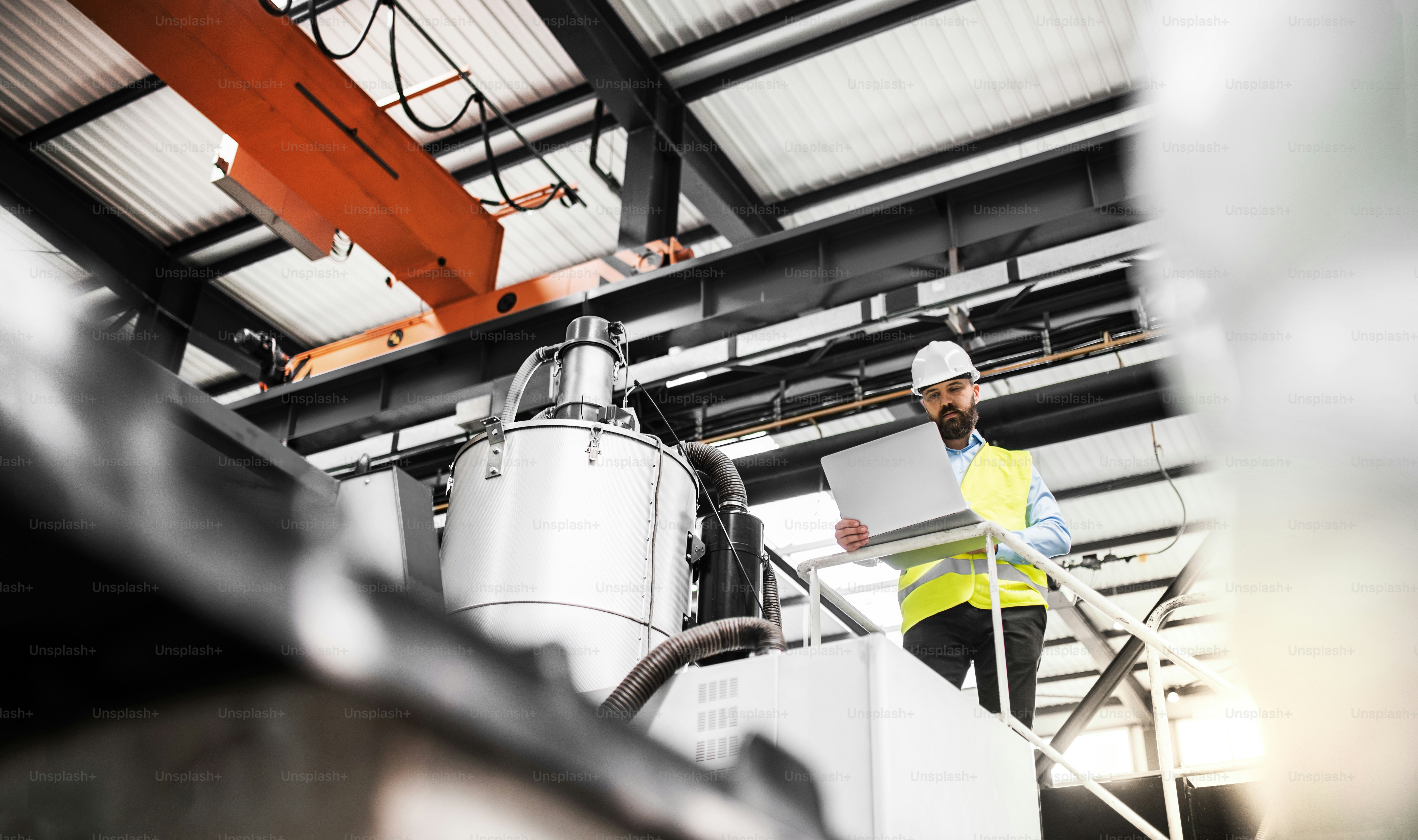 A portrait of a happy industrial woman engineer standing in a factory ...