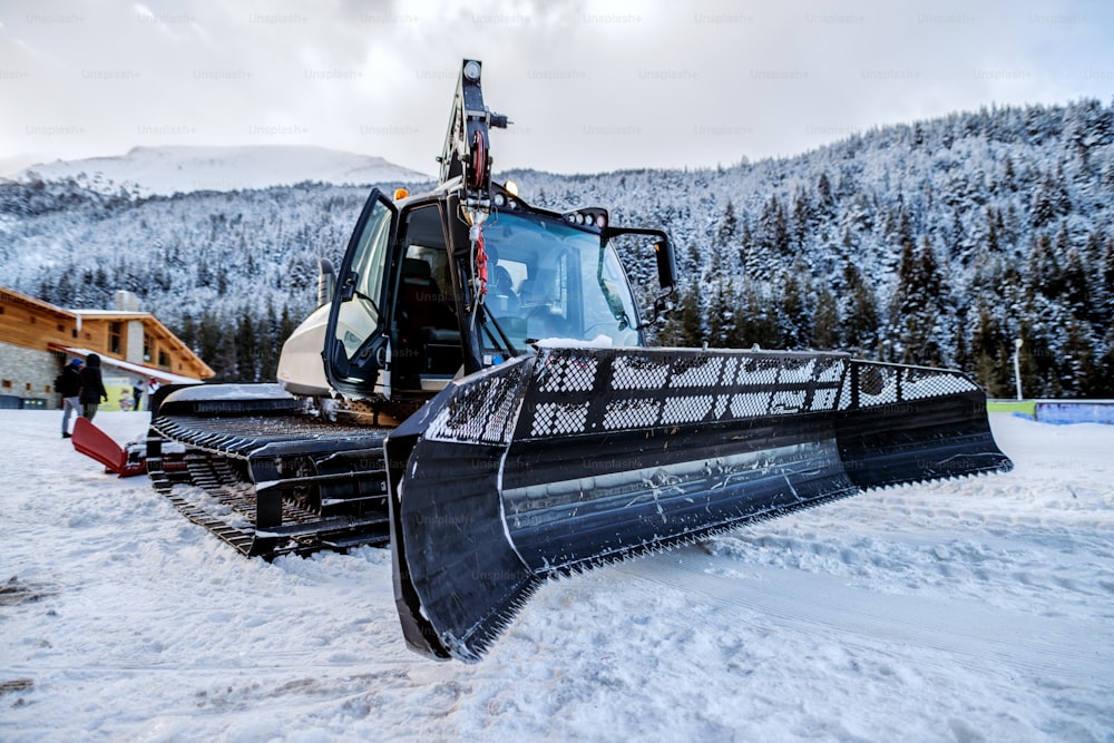 Bulldozer che pulisce la neve in montagna. Rendere la strada pulita per l'auto.