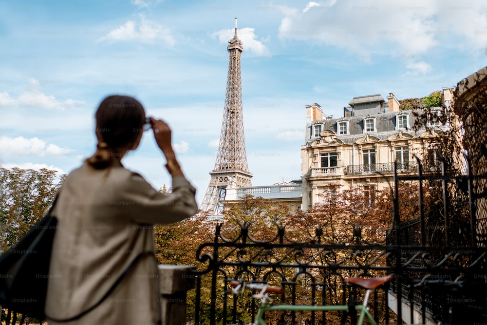 Mulher que aprecia a vista sobre a torre Eiffel em Paris. Imagem focada no fundo