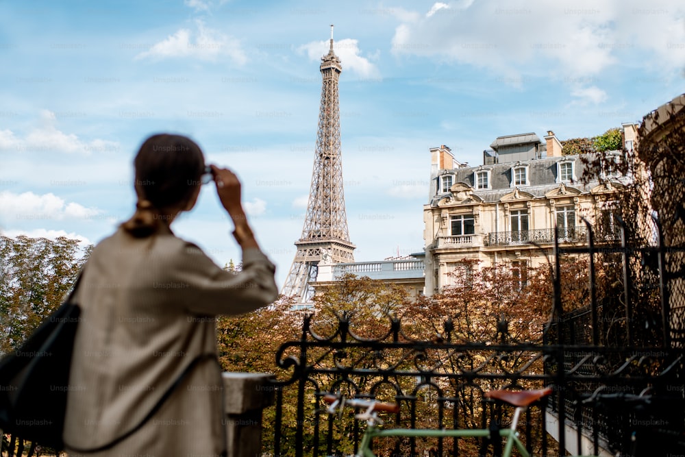 Woman enjoying view on the Eiffel tower in Paris. Image focused on the background