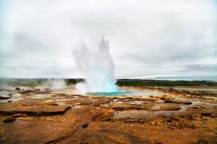 Erupção de gêiseres em uma bela paisagem da Islândia, Europa.