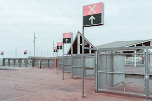 Vários port�ões de checkpoint para a área onde ocorrem concertos ou grandes eventos esportivos, muitos postes com setas e sinais de cruz nas bandeiras no topo, cerca de malha que se estende até a distância