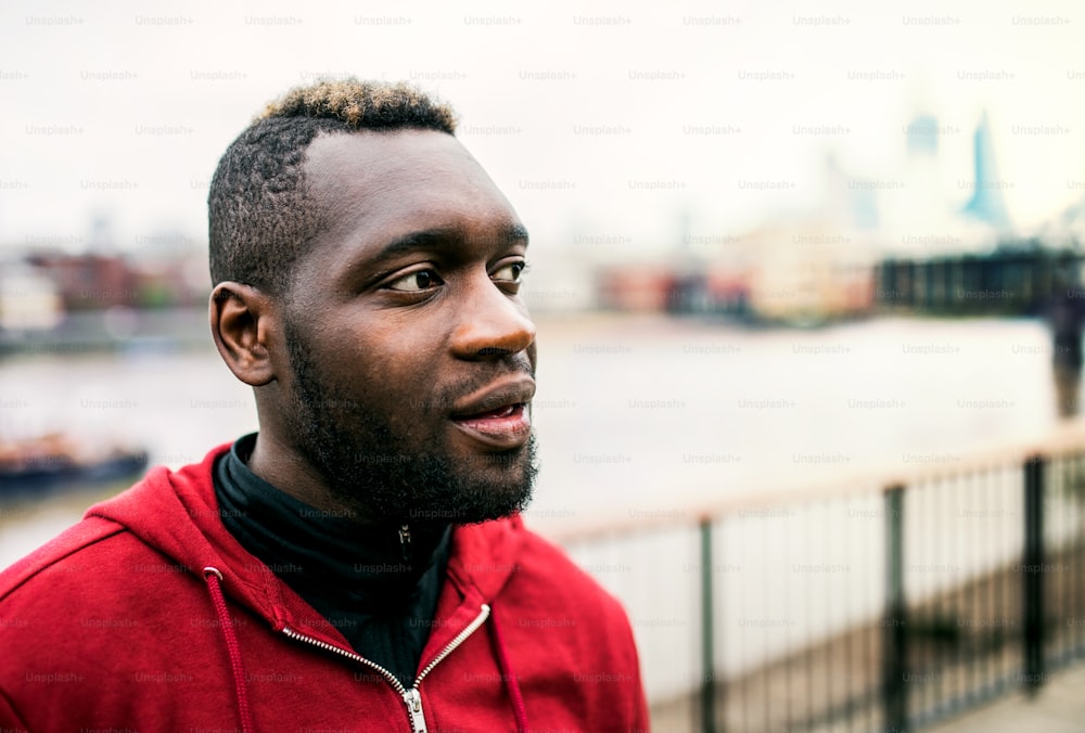 A close-up of black man runner standing in a city. Copy space.