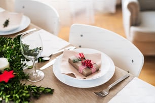 Un primer plano de una mesa puesta para una cena en casa en Navidad.