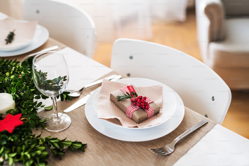 Un primo piano di una tavola apparecchiata per una cena a casa nel periodo natalizio.