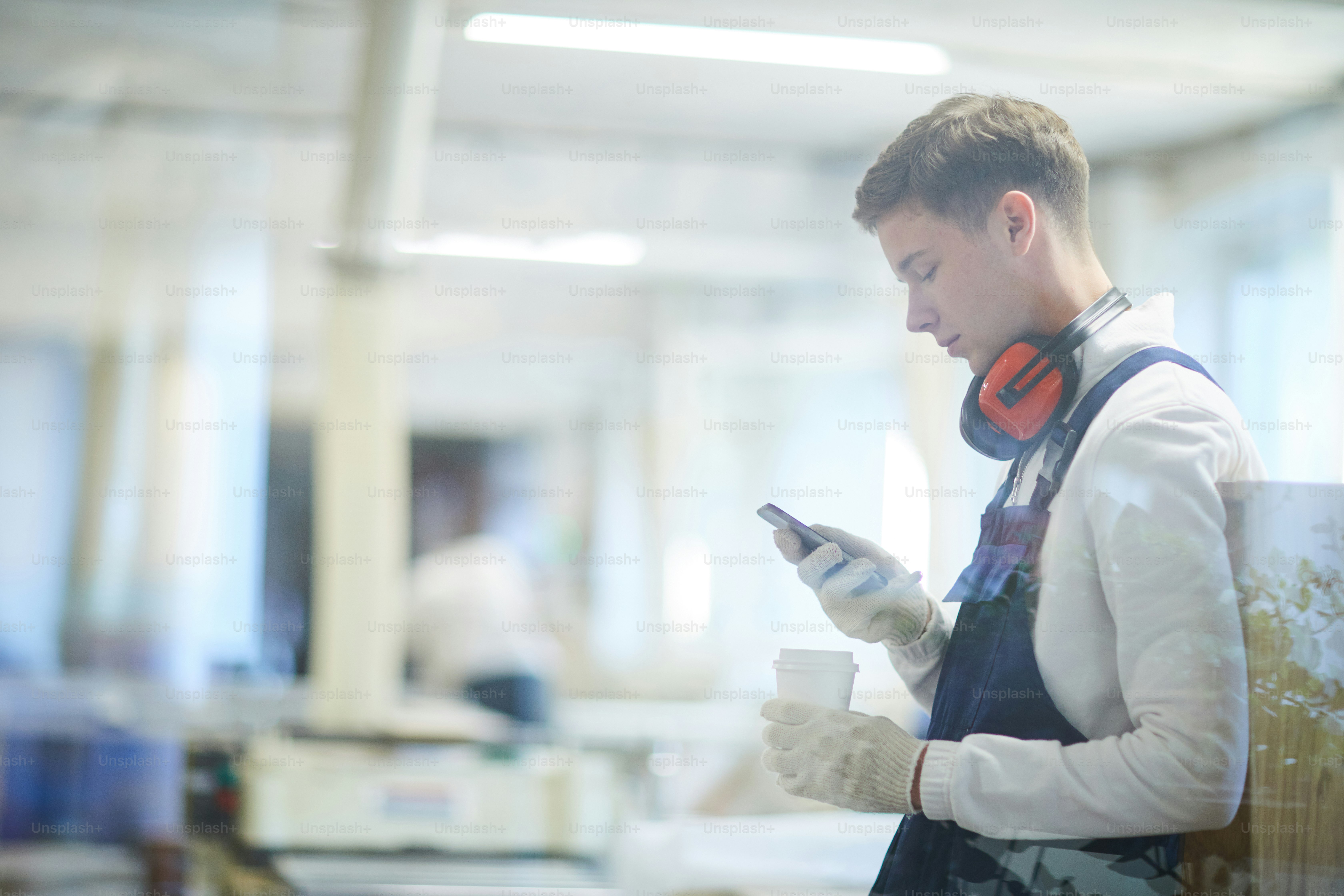 Serious concentrated young construction worker in ear protectors and ...