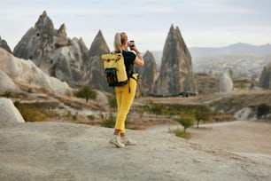 Donna che viaggia, scattando foto al telefono del paesaggio naturale. Femmina con zaino che fa foto. Alta risoluzione