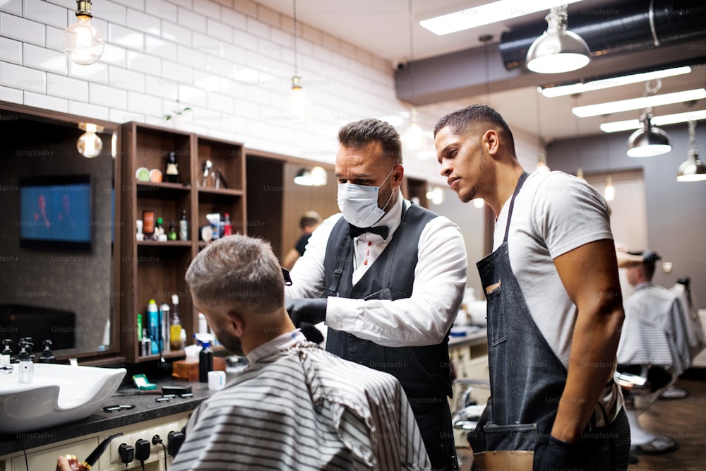 Cliente homem hipster bonito visitando haidresser e cabeleireiro em barbearia, conceito de treinamento.