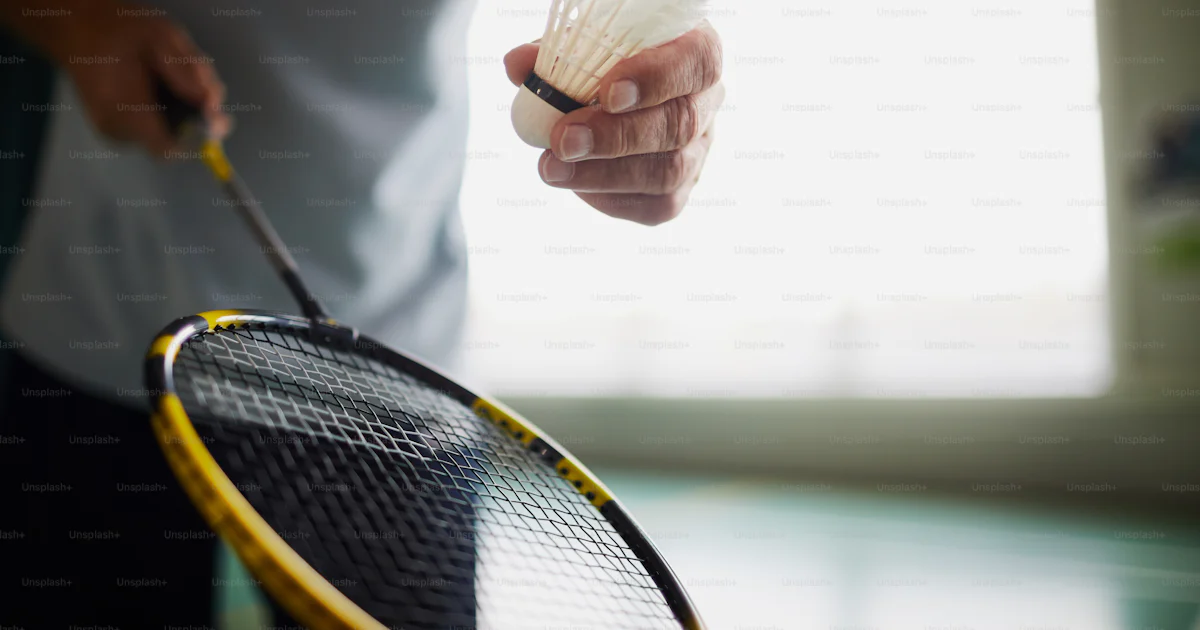 Badminton player holding racket and shuttlecock while going to throw ...
