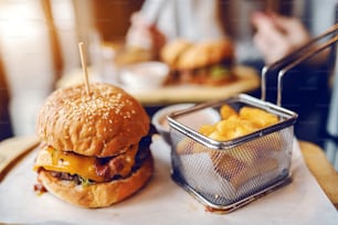 Close up of delicious burger and fries on plate.