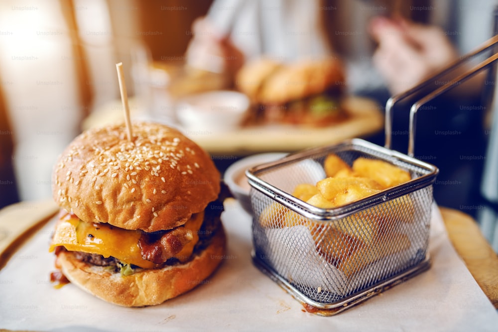 Primo piano di deliziosi hamburger e patatine fritte sul piatto.