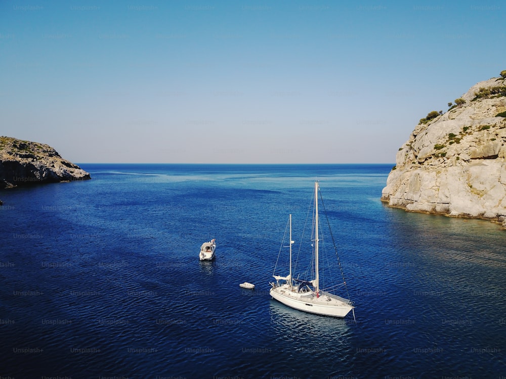 Aerial shot of beautiful blue lagoon at hot summer day with sailing boat. Top view.