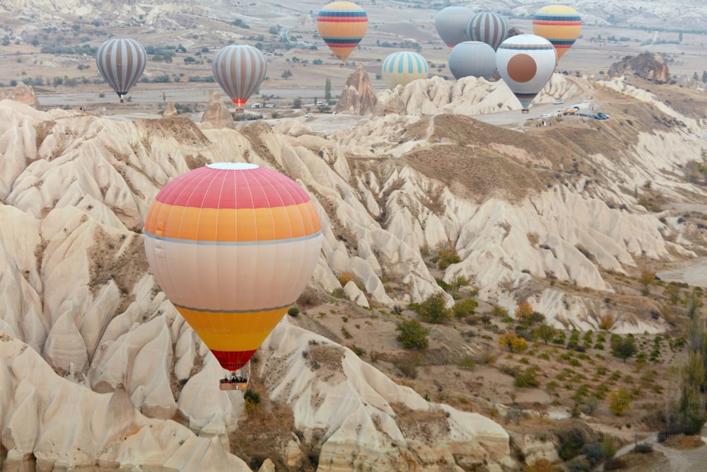 Bunte Heißluftballons fliegen am Himmel über den Bergen Kappadokiens. Hohe Auflösung