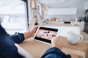 A midsection of man with tablet, looking at interior design sketches. A new home concept.