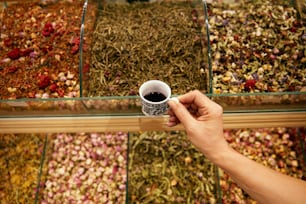 店の接写でトルコの紅茶のカップを手に、市場の背景にお茶の品揃え。高解像度