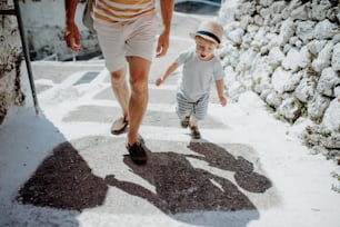 Ein Mittelteil eines unwiederzuerkennenden Vaters mit einem kleinen Sohn, der in den Sommerferien in der Stadt spazieren geht.