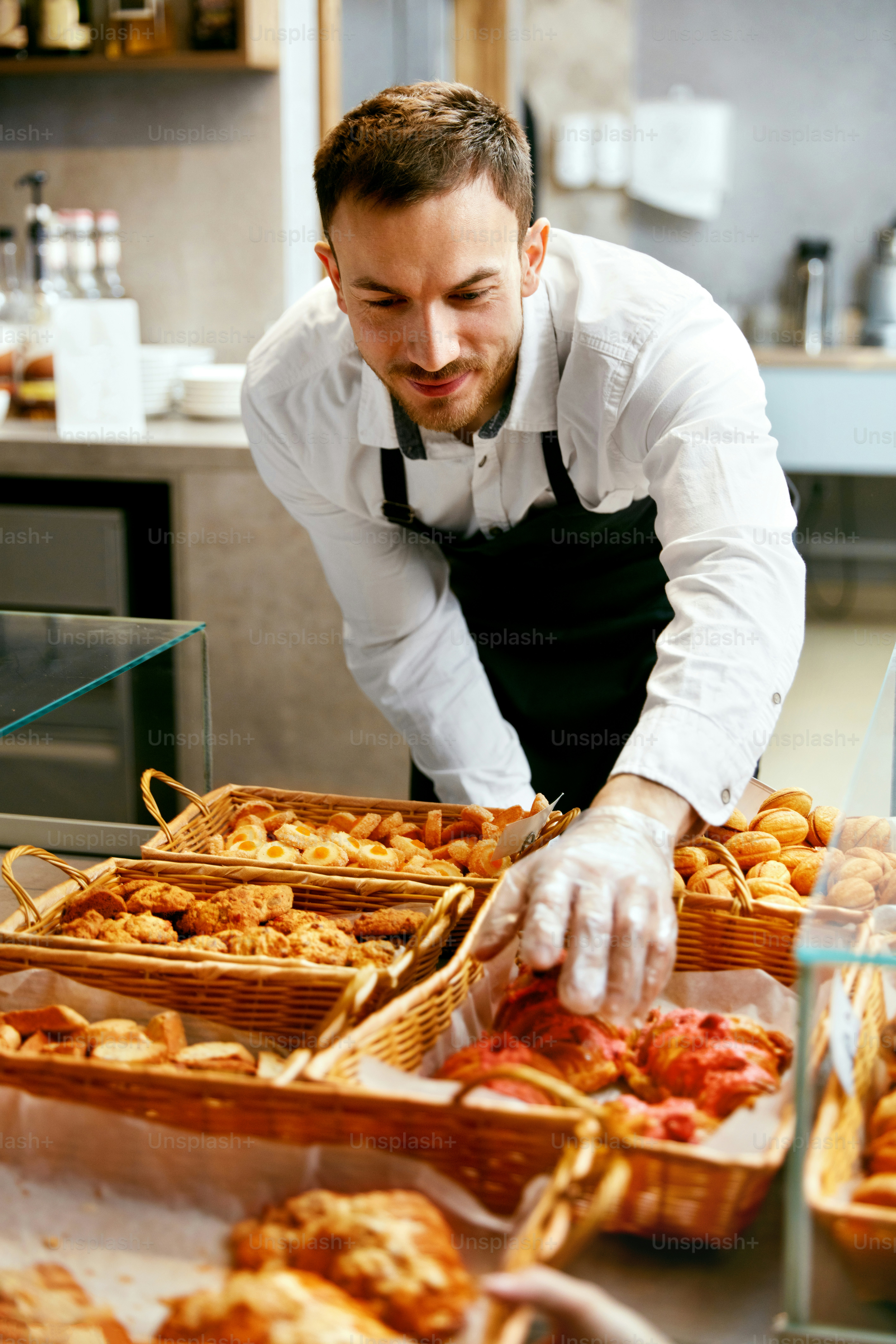 Man In Apron Selling Fresh Bakery In Cozy Pasrty Shop. High Resolution.