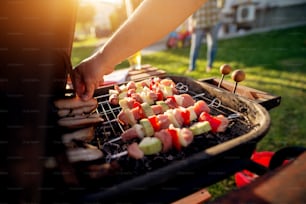 There is just enough space for a thick bacon slices to be put on a grill heat above the juicy and fresh meat and vegetables on a stick.