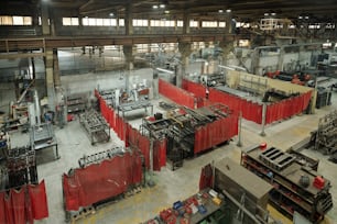 빨간 커튼으로 나뉘어 있는 작업장 그룹이 있는 현대 공장의 대형 산업 공장 일부의 모습