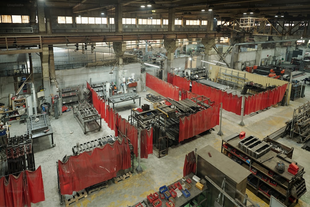 빨간 커튼으로 나뉘어 있는 작업장 그룹이 있는 현대 공장의 대형 산업 공장 일부의 모습