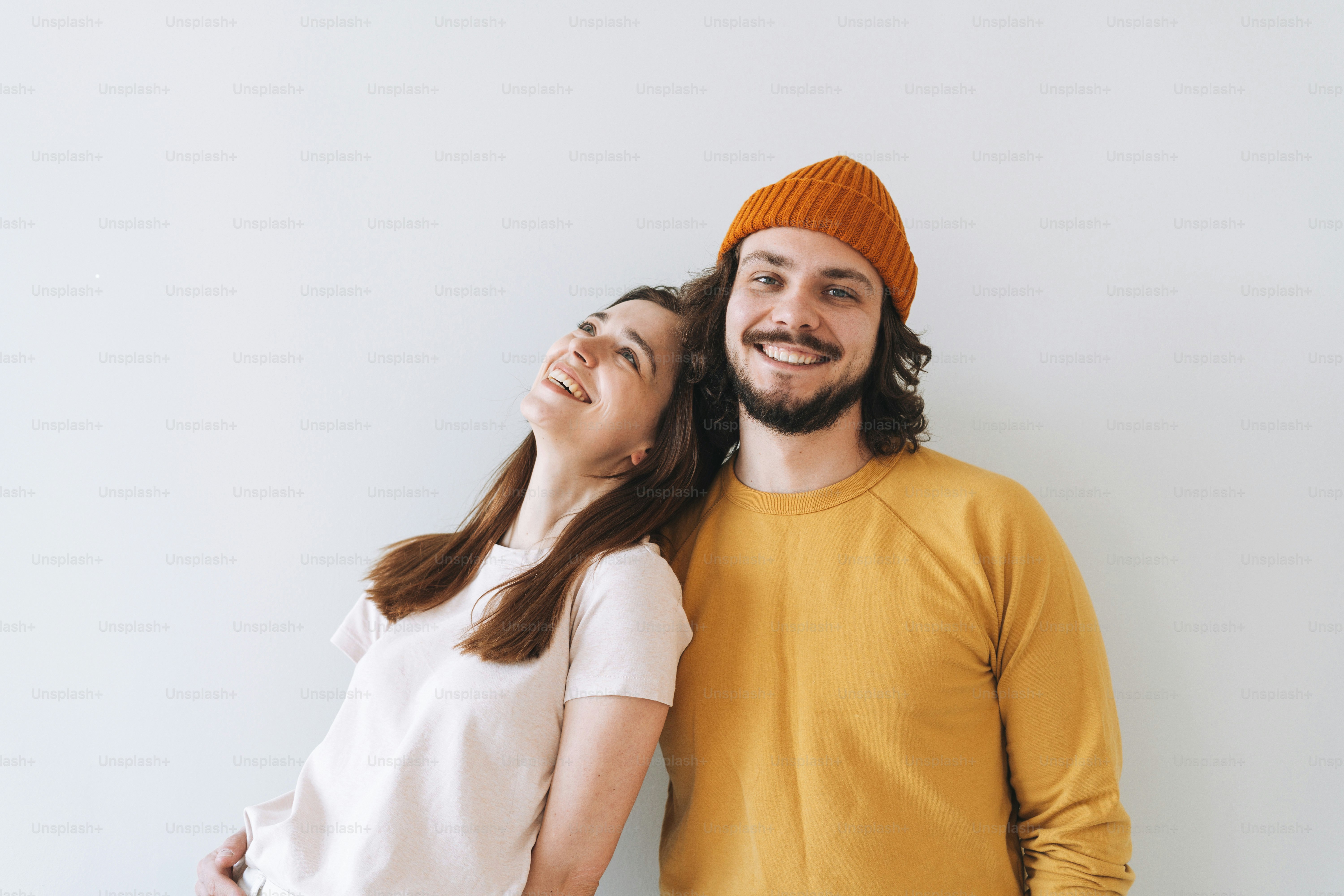 Portrait of happy couple young family laughing against gray wall