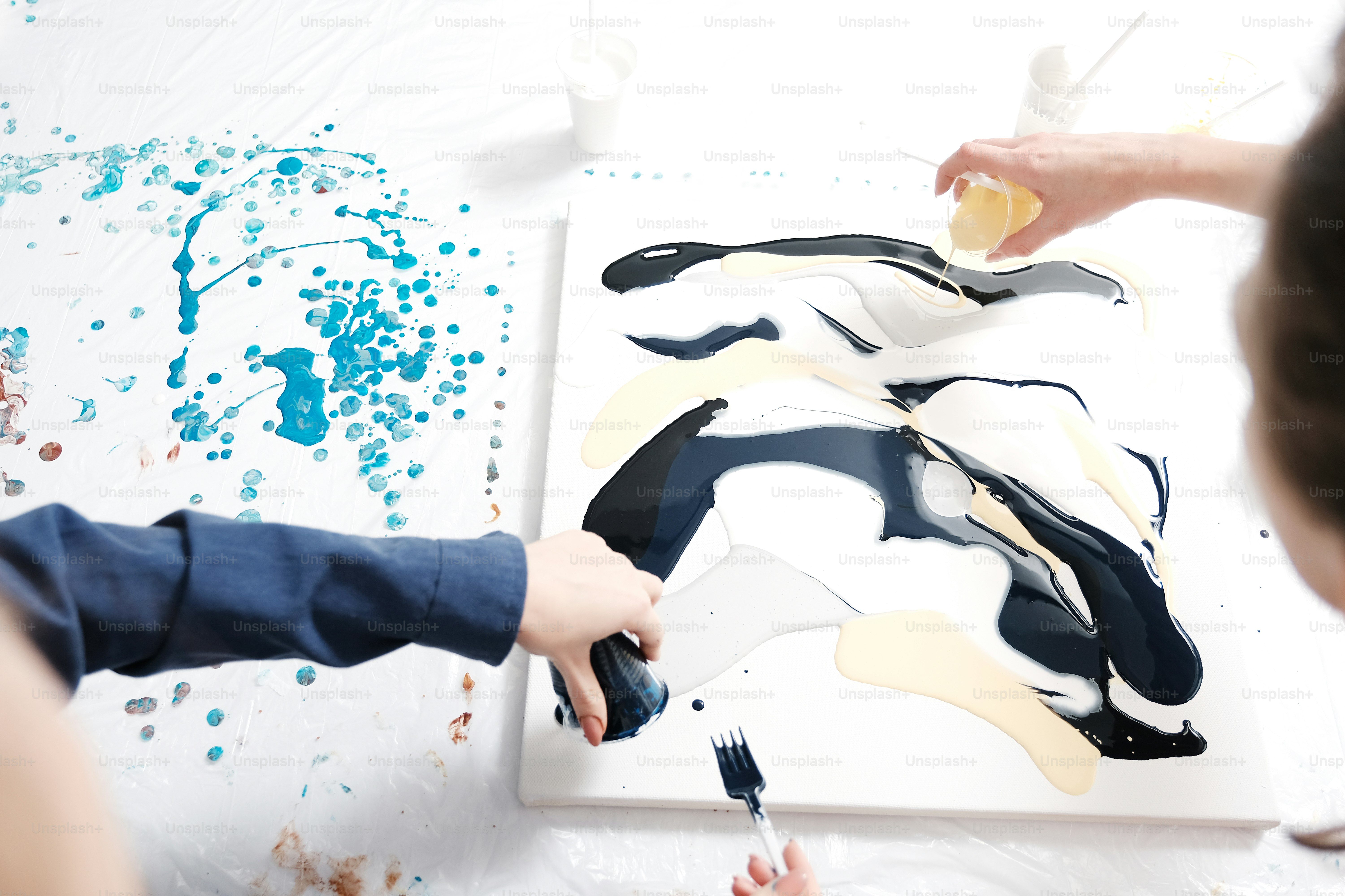 Young girl artist in the Studio is provisioned, mix acrylic paint, prepares the way for drawing. A woman painter. Accessories for drawing. A new technique of painting. Canvas, frame. Art workshop. Creative ideas. Abstraction