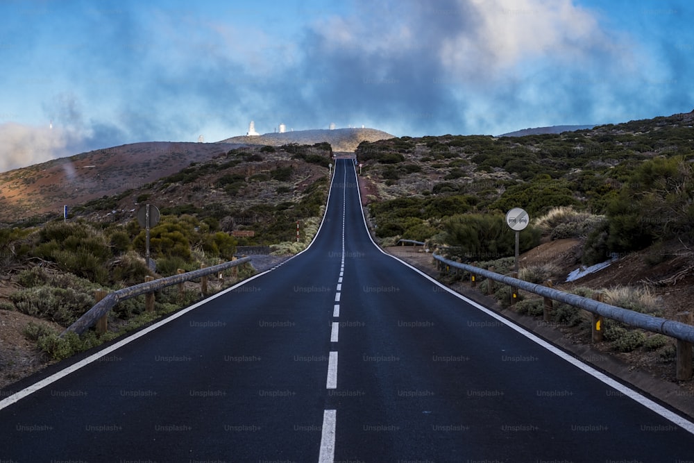 long perfect road to travel to the observatory at el teide vulcan mount. straight to the destination under a blue nice sky.