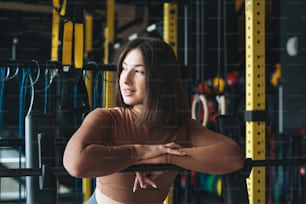 Retrato de una mujer morena joven en ropa deportiva activa en el gimnasio del club de fitness