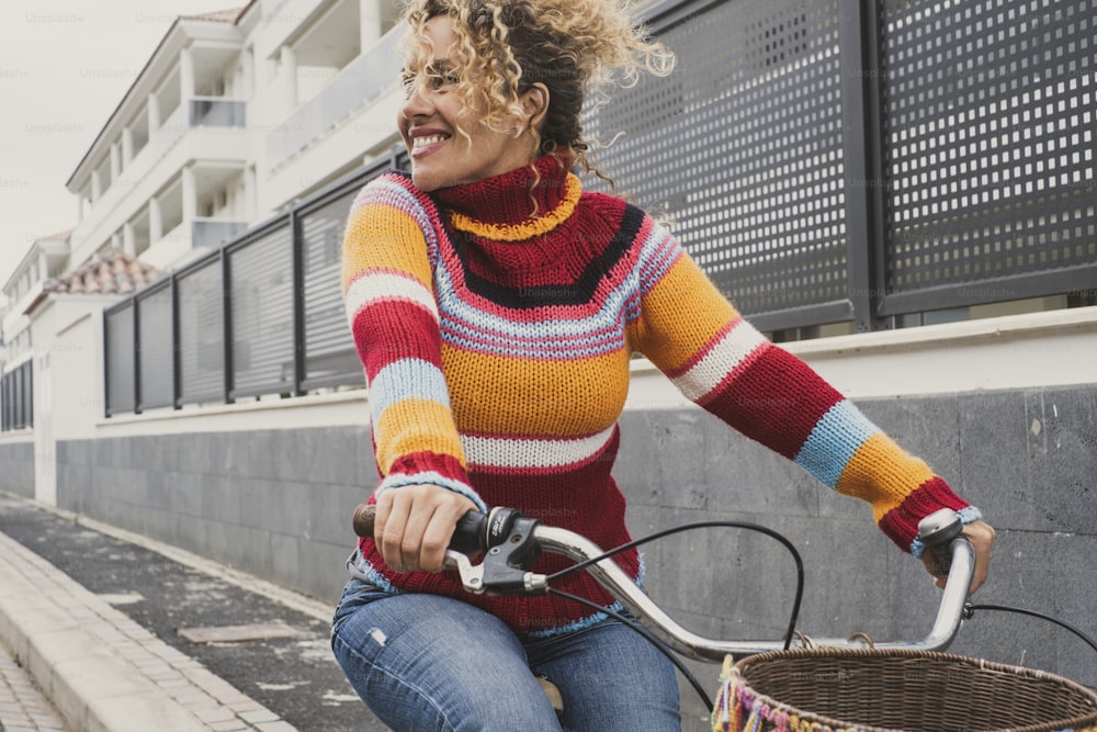 행복한 성숙한 젊은 여성이 자전거를 타고 야외 활동을 즐기며 웃고 있다. 자전거를 사용하는 여성과의 녹색 분위기와 환경 교통 수단
