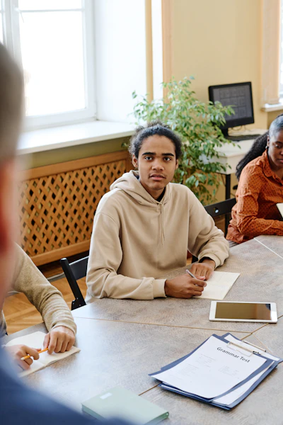 Black teenager taking notes during a classroom lesson