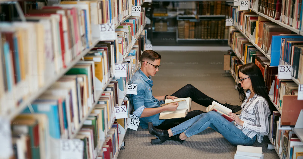 Students Studying In University Library. Man And Woman Reading Books ...