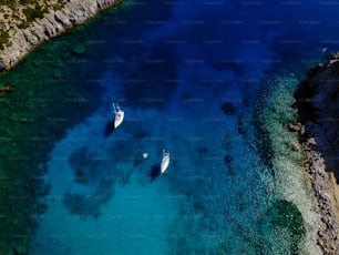 Aerial shot of beautiful blue lagoon at hot summer day with sailing boat.