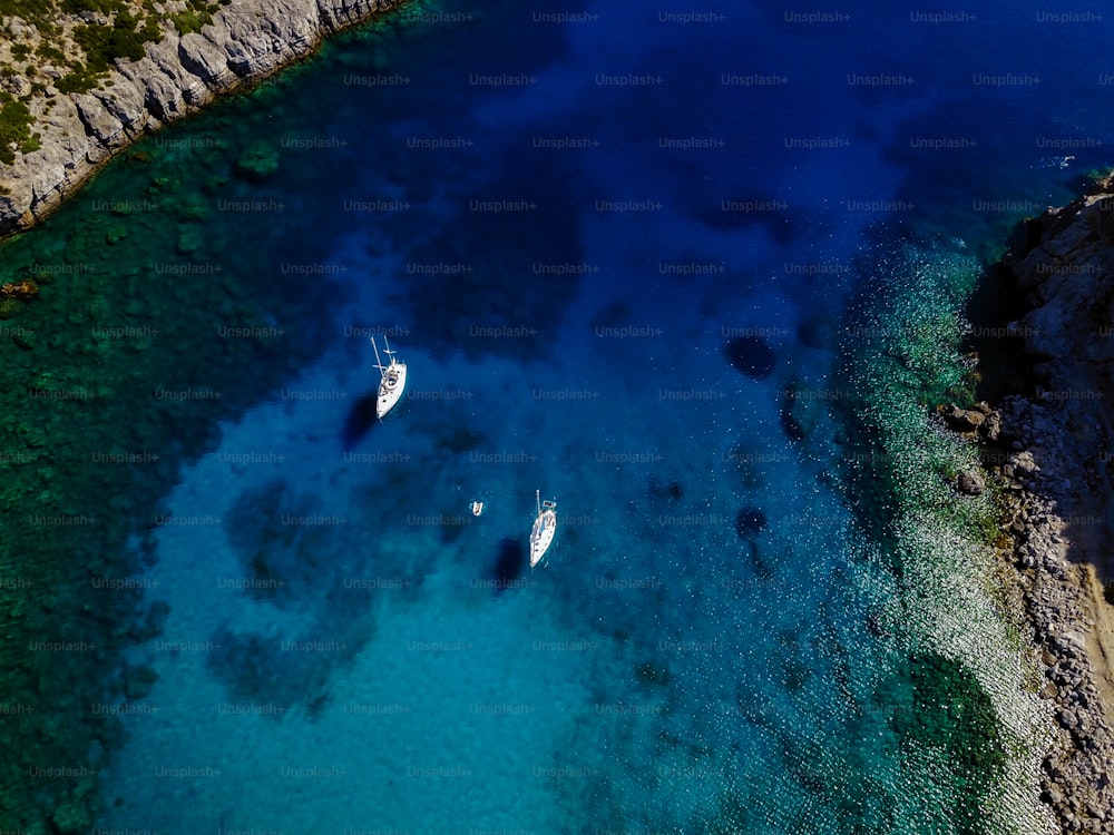 Aerial shot of beautiful blue lagoon at hot summer day with sailing boat.