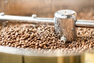Vista de cerca de los granos de café tostados enfriándose en la máquina tostadora