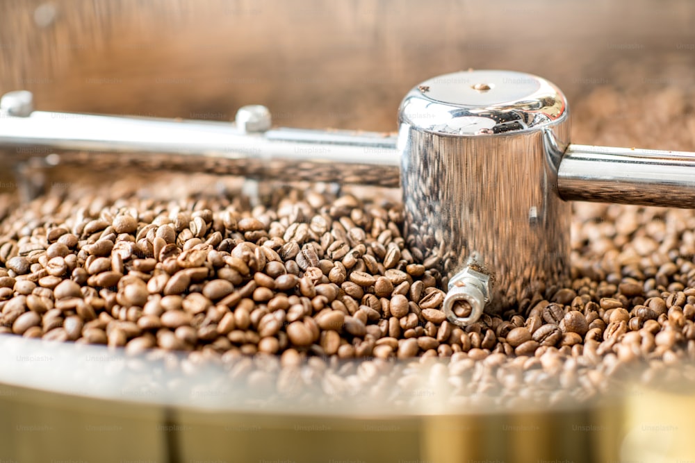 Vue rapprochée sur les grains de café torréfiés refroidissant dans la machine de torréfaction