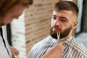 Beard Cut In Barber Shop. Barber Cutting Man's Beard With Scissors, Doing Haircut. High Resolution