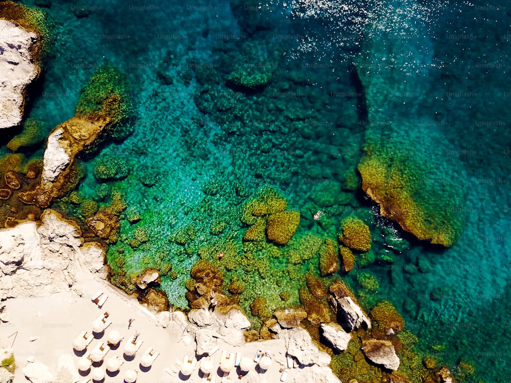 Vista superior de la playa con turistas nadando en hermosas aguas cristalinas.
