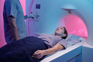 Young woman on medical table moving into mri scan machine for medical examination