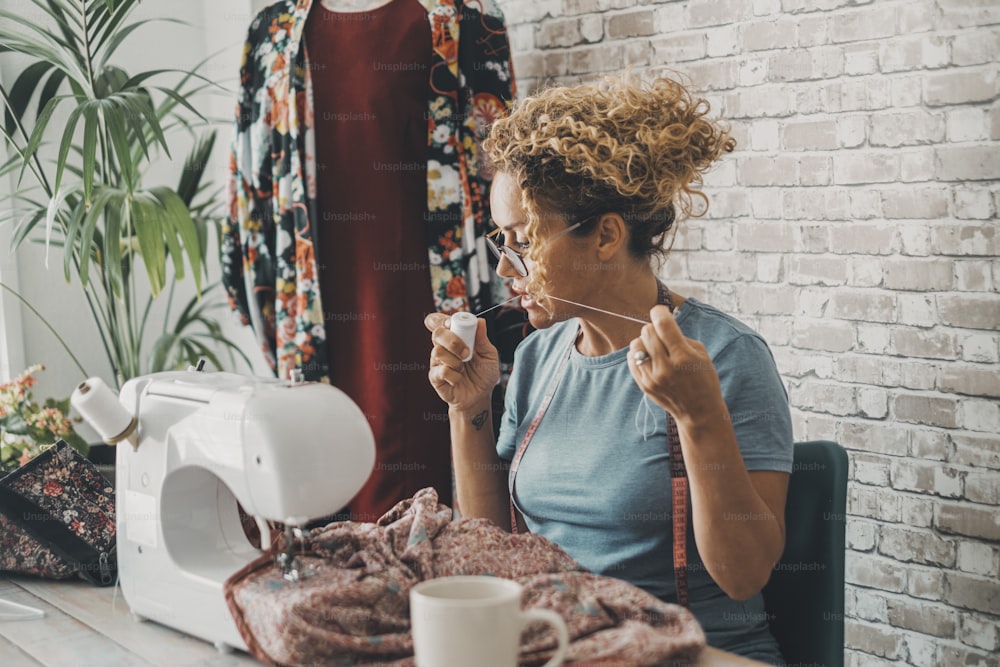 Woman at home use sewing machine for tailoring business activity creating vintage dresses. Circular market concept lifestyle. Tailor female people create and modofy clothes for work or hobby.