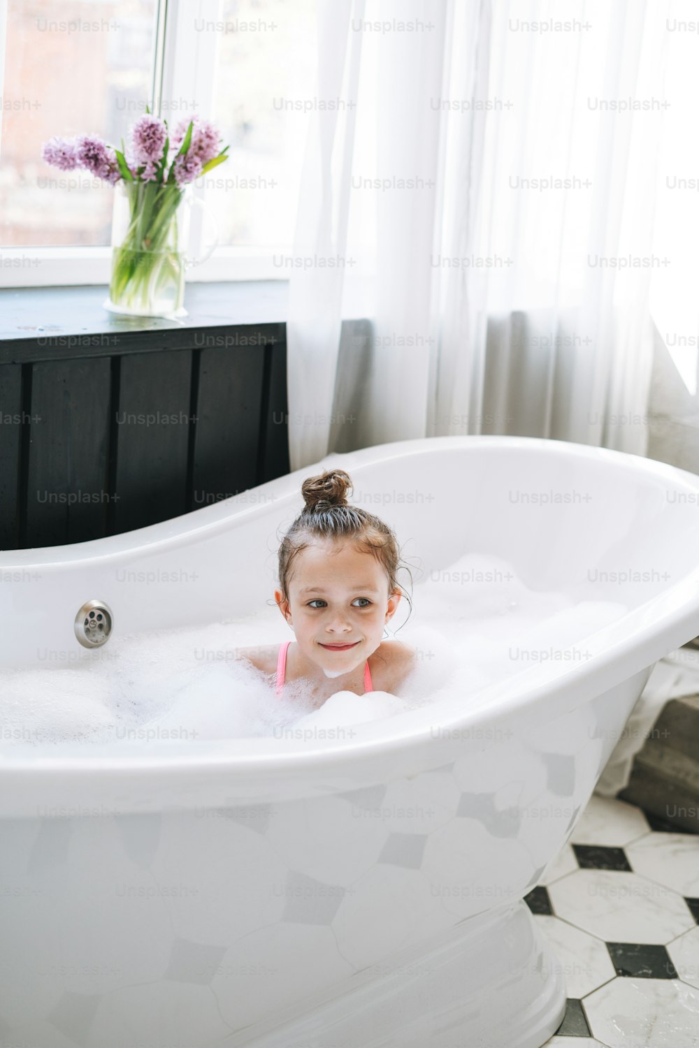 집에서 거품으로 목욕을 즐기는 행복한 소녀