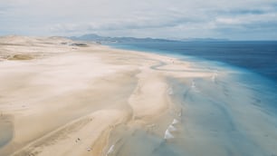 Amazing tropical beach anc blue transparent sea ocean water. Aerial view of coastline and amazing seascape landscape with horizon and sky and mountains in background. Summer travel