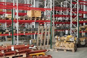 Ampio magazzino con varietà di pezzi di ricambio per macchinari e scaffalature con casse all'interno di un grande e moderno stabilimento industriale
