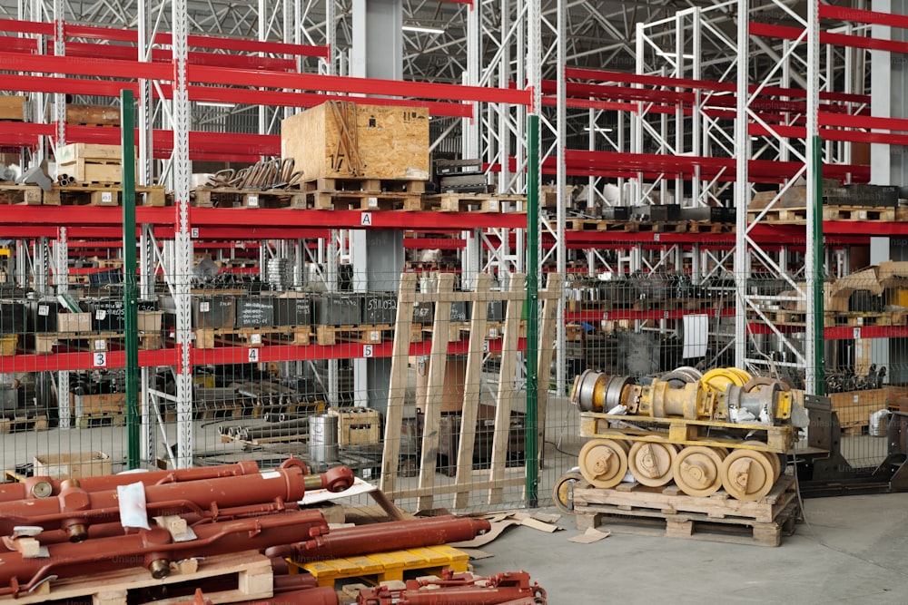 Amplio almacén con variedad de repuestos para maquinaria y estanterías con cajas dentro de una gran planta industrial moderna