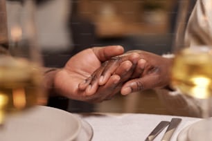 Les mains d’un jeune homme et d’une jeune femme africains ont servi une table de fête pendant la prière avant le dîner de Noël
