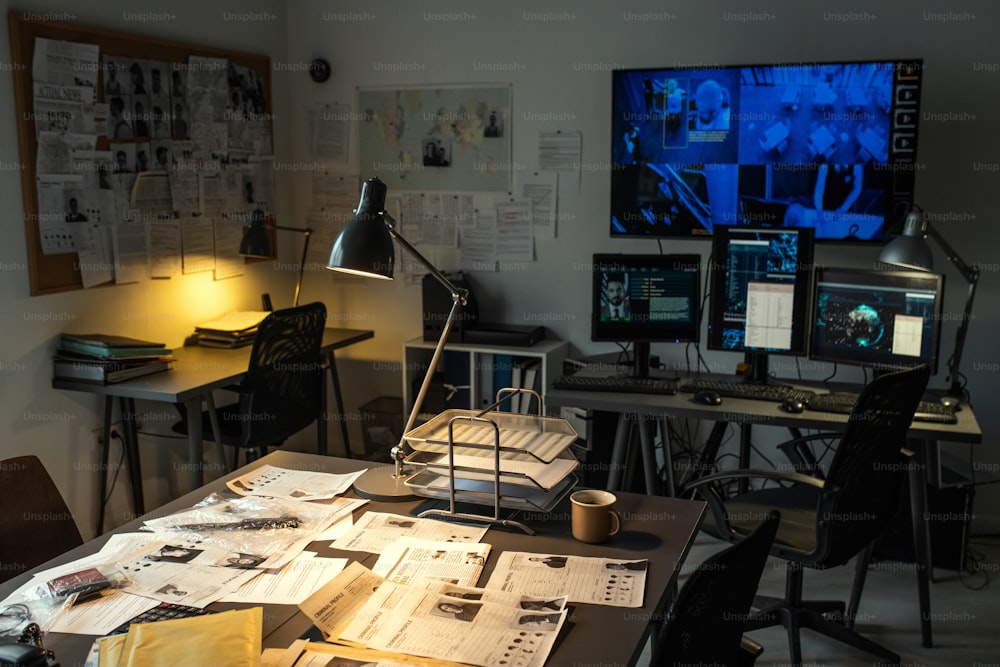 Interior de la oficina federal de investigaciones contemporánea con lugar de trabajo de agentes y cámara de seguridad en computadoras y pantalla grande
