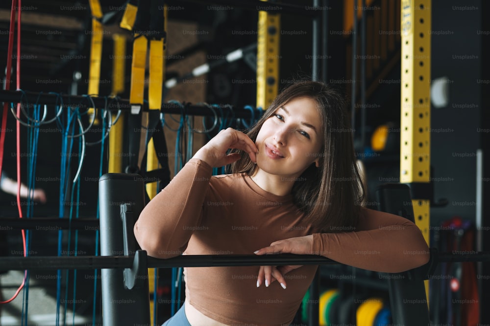 Ritratto di giovane donna bruna in abbigliamento sportivo attivo nella palestra del fitness club