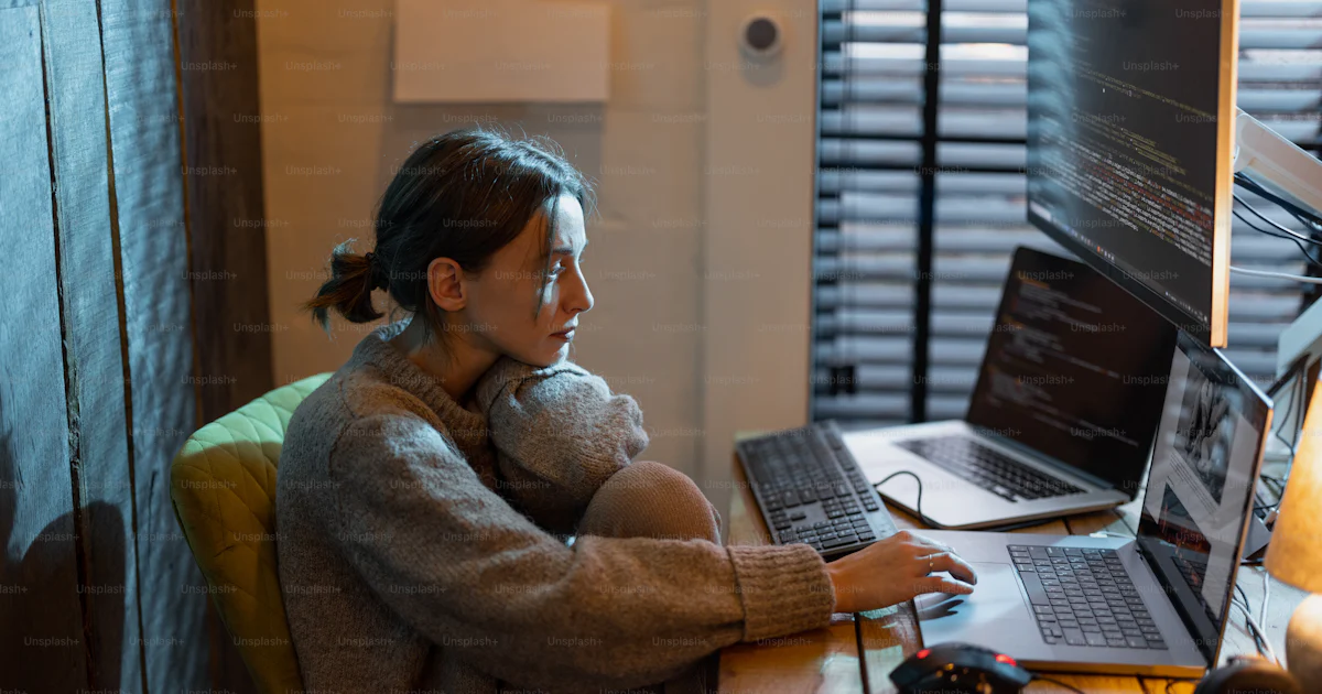 Young focused woman feeling overworked and tired, working on laptop and ...