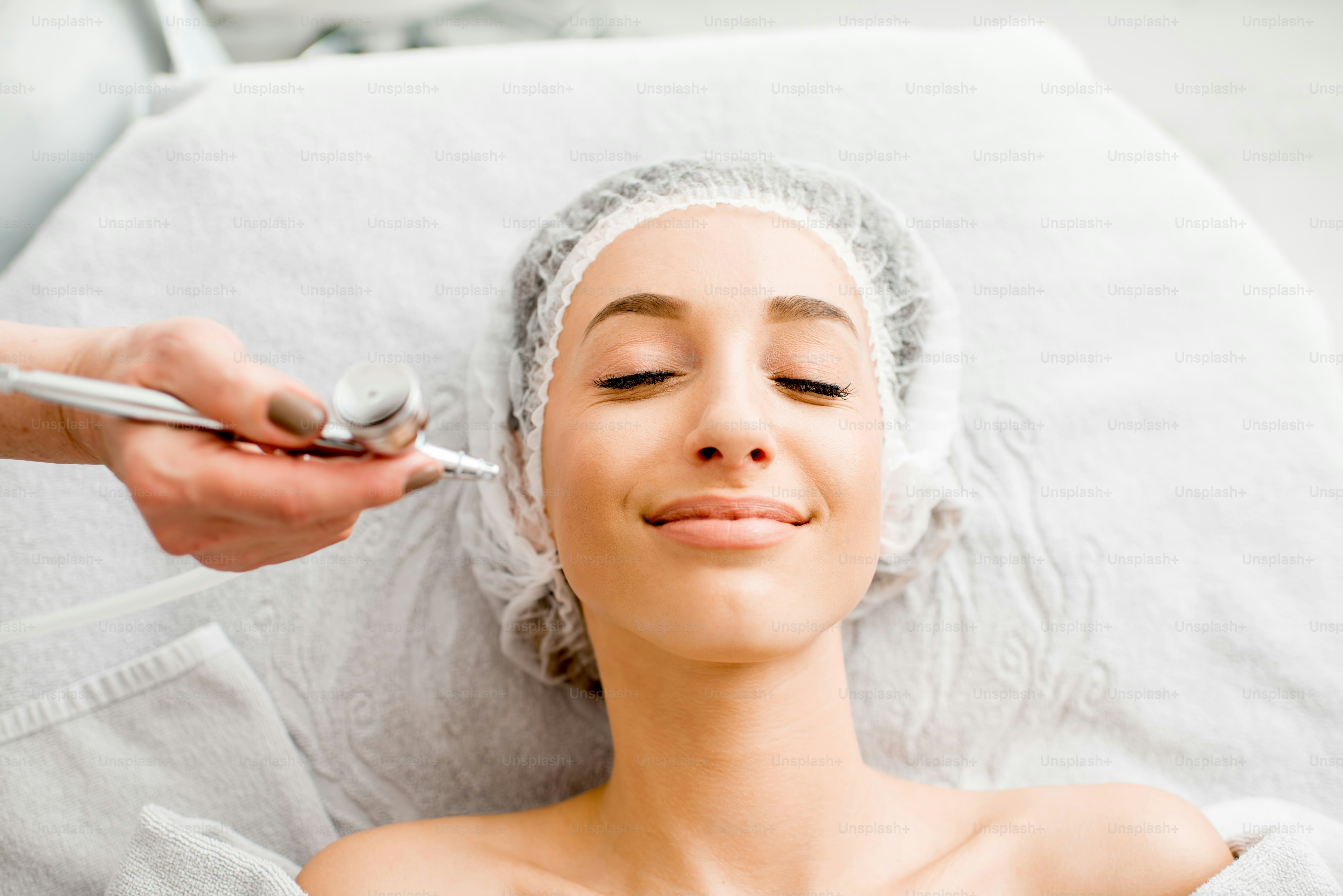 Young woman during the professional hydration procedure on the face in the cosmetological office