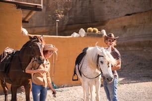 nice caucasian couple outdoor prepare and check horse equipment ready to go live a new adventure travel in alternative way to discover a natural paths and world. country life concepts for young man and woman