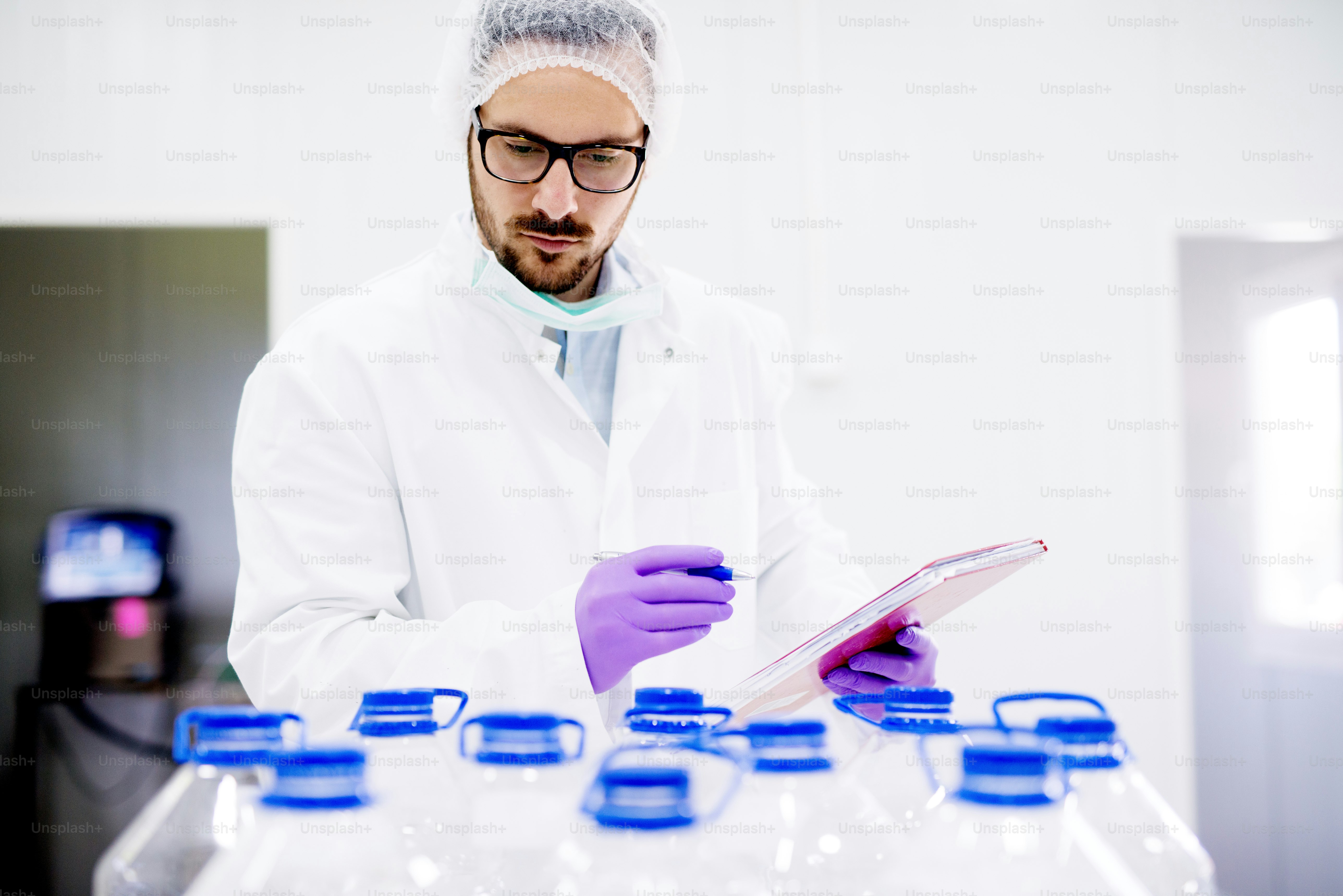 Chemist doing quality control of bottled water. checking whether it